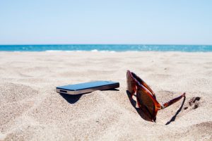 Smartphone and sunglasses on the beach